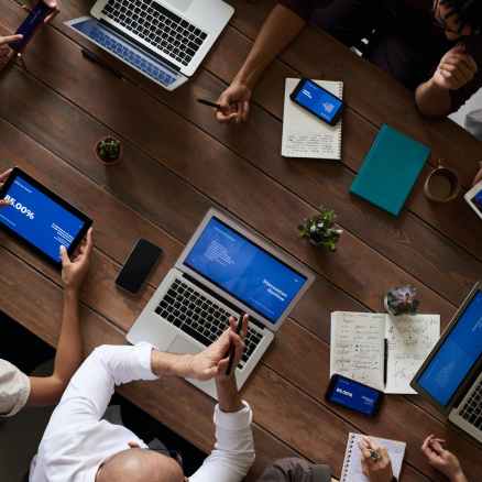 photo of people leaning on wooden table